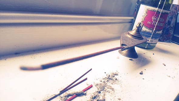 Incense stick in a tiny oil lamp.