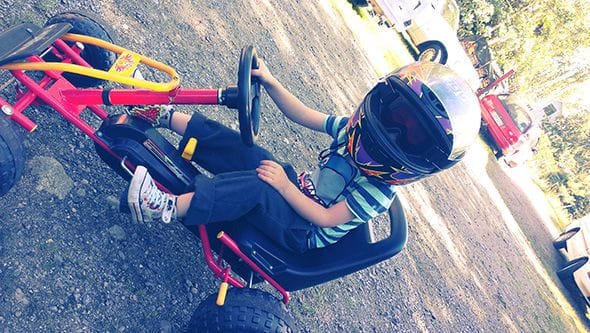 Lucien sitting in pedal-powered go-kart.