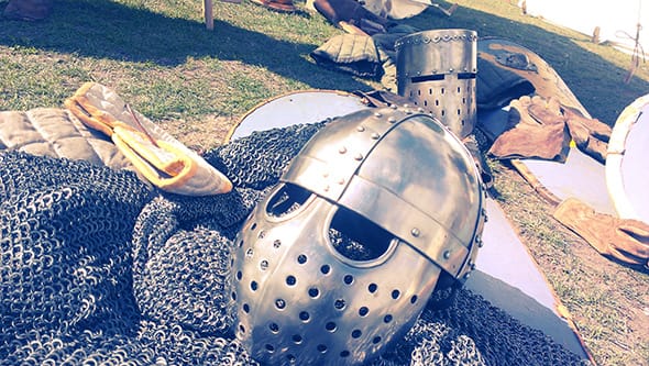 Real medieval helmets and chainmail armour on a table.