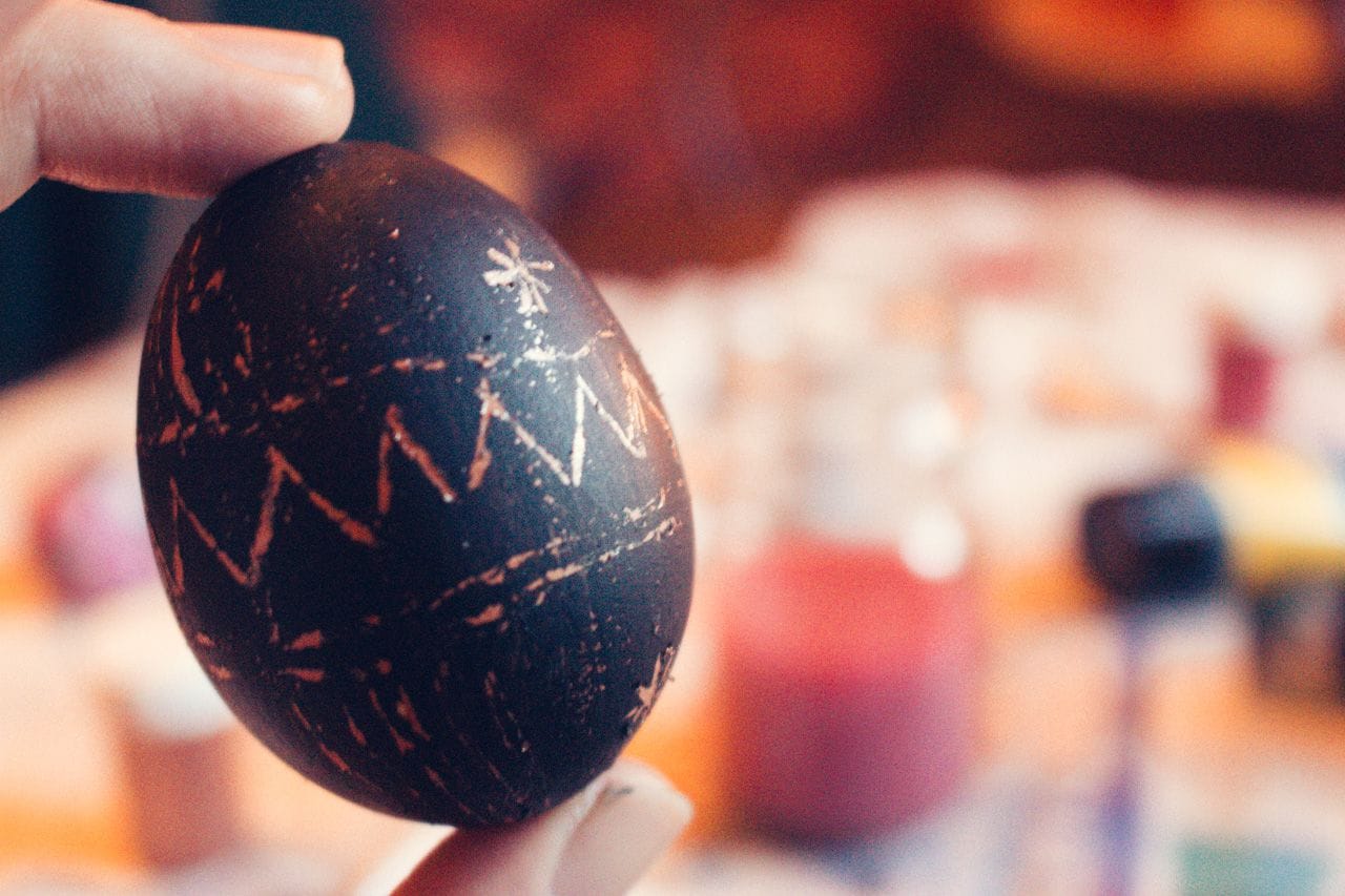 Carlos holding up his Easter egg, painted bronze and black.